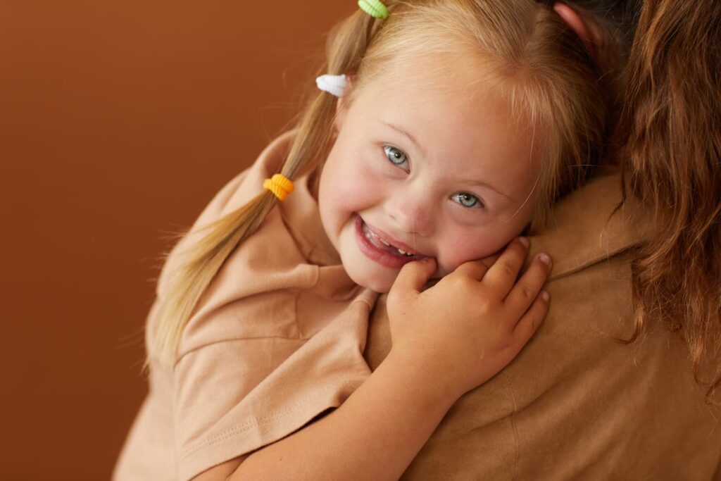 An image of a Cute Girl with Down Syndrome in her Mothers Arms.