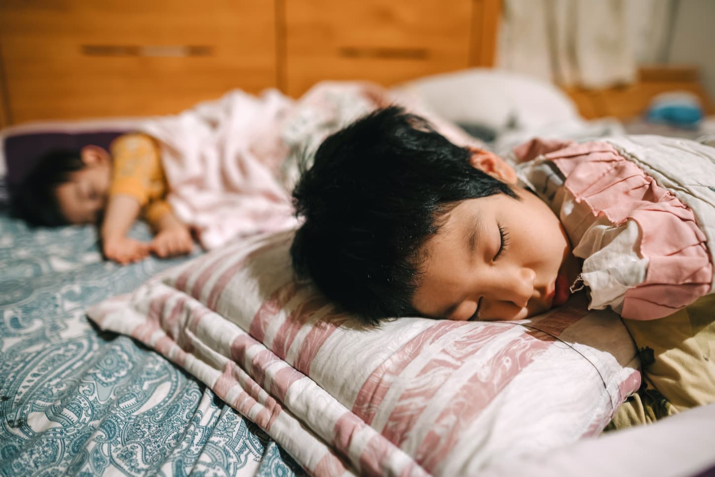An image of kids between 1-3 years old sleeping in bed.
