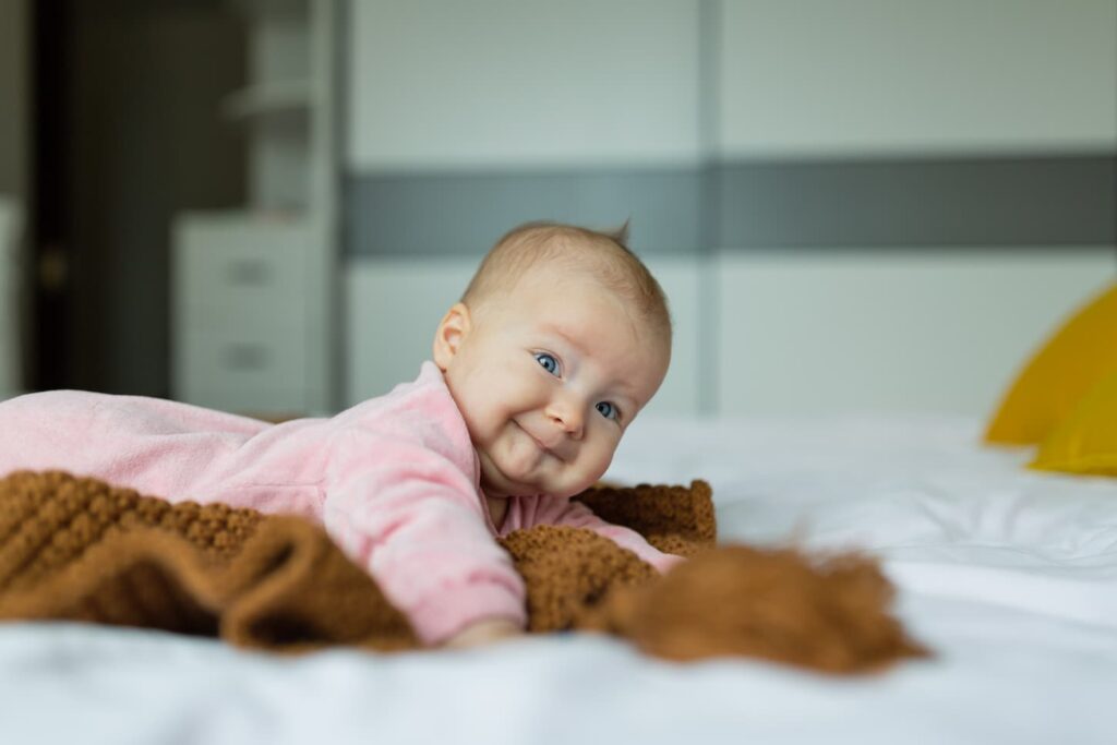 An image of a Cute Baby Girl 4 Months Old Lying on Bed at Home.