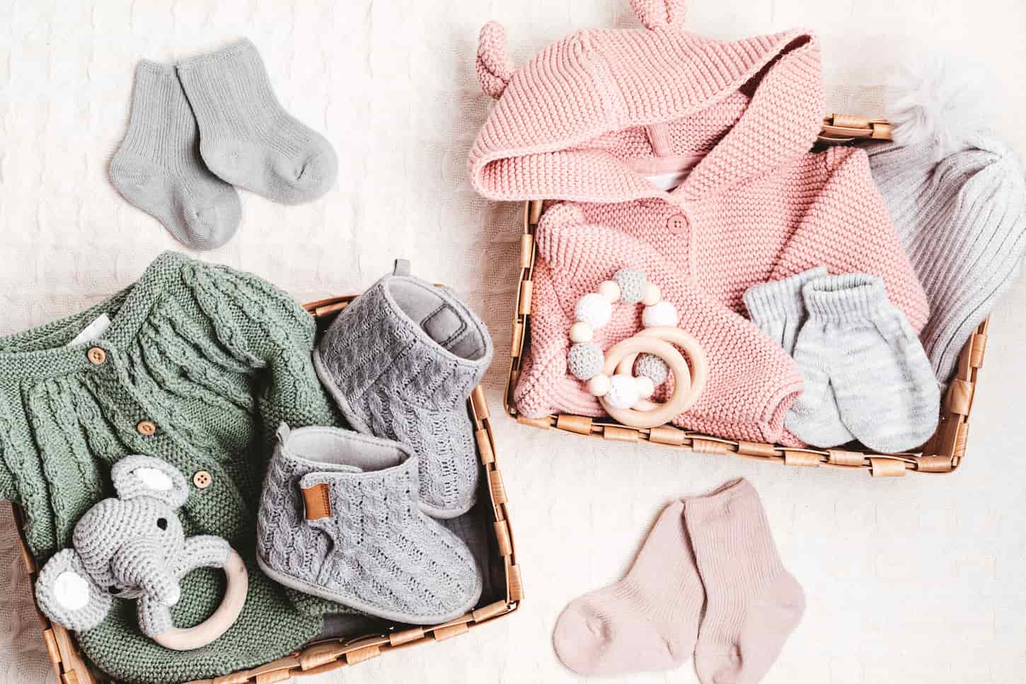 An image of a Set of cute organic baby clothes, toys, and booties. Heartwarming present for cold weather.
