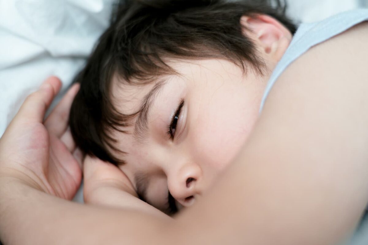 An image of a Young Kid sleeping with open-eyed while taking a nap, Sleep problems in young children concept or REM sleep.